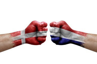 Two hands punch to each others on white background. Country flags painted fists, conflict crisis concept between denmark and netherlands