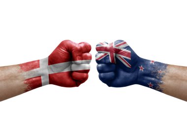 Two hands punch to each others on white background. Country flags painted fists, conflict crisis concept between denmark and new zealand