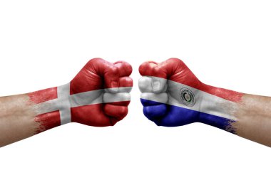 Two hands punch to each others on white background. Country flags painted fists, conflict crisis concept between denmark and paraguay