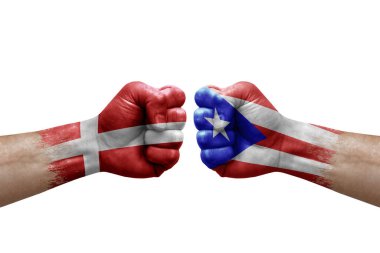 Two hands punch to each others on white background. Country flags painted fists, conflict crisis concept between denmark and puerto rico