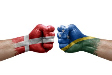 Two hands punch to each others on white background. Country flags painted fists, conflict crisis concept between denmark and solomon islands