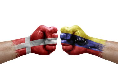 Two hands punch to each others on white background. Country flags painted fists, conflict crisis concept between denmark and venezuela