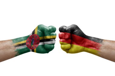 Two hands punch to each others on white background. Country flags painted fists, conflict crisis concept between dominica and germany