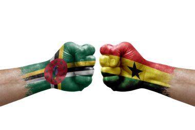 Two hands punch to each others on white background. Country flags painted fists, conflict crisis concept between dominica and ghana