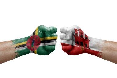 Two hands punch to each others on white background. Country flags painted fists, conflict crisis concept between dominica and gibraltar