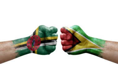 Two hands punch to each others on white background. Country flags painted fists, conflict crisis concept between dominica and guyana