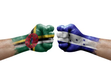 Two hands punch to each others on white background. Country flags painted fists, conflict crisis concept between dominica and honduras