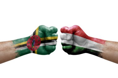 Two hands punch to each others on white background. Country flags painted fists, conflict crisis concept between dominica and hungary