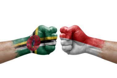 Two hands punch to each others on white background. Country flags painted fists, conflict crisis concept between dominica and indonesia