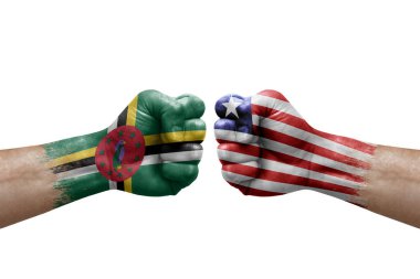 Two hands punch to each others on white background. Country flags painted fists, conflict crisis concept between dominica and liberia