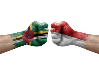 Two hands punch to each others on white background. Country flags painted fists, conflict crisis concept between dominica and monaco