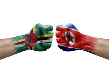 Two hands punch to each others on white background. Country flags painted fists, conflict crisis concept between dominica and north korea