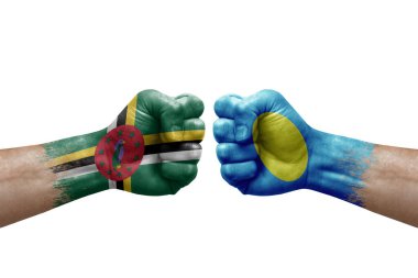 Two hands punch to each others on white background. Country flags painted fists, conflict crisis concept between dominica and palau