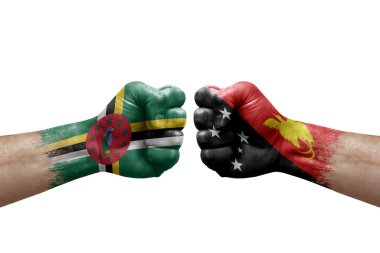 Two hands punch to each others on white background. Country flags painted fists, conflict crisis concept between dominica and papua new guinea