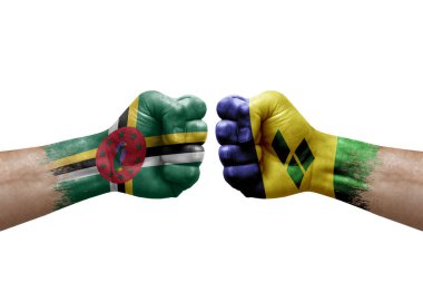 Two hands punch to each others on white background. Country flags painted fists, conflict crisis concept between dominica and saint vincent and the grenadines