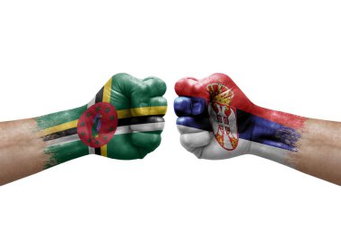 Two hands punch to each others on white background. Country flags painted fists, conflict crisis concept between dominica and serbia