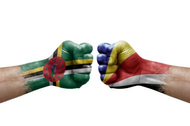 Two hands punch to each others on white background. Country flags painted fists, conflict crisis concept between dominica and seychelles