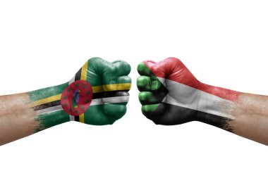 Two hands punch to each others on white background. Country flags painted fists, conflict crisis concept between dominica and sudan