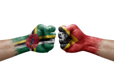 Two hands punch to each others on white background. Country flags painted fists, conflict crisis concept between dominica and timor leste