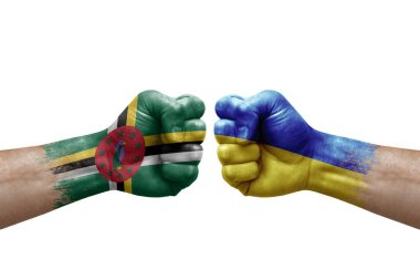 Two hands punch to each others on white background. Country flags painted fists, conflict crisis concept between dominica and ukraine