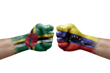 Two hands punch to each others on white background. Country flags painted fists, conflict crisis concept between dominica and venezuela