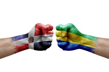 Two hands punch to each others on white background. Country flags painted fists, conflict crisis concept between dominican republic and gabon