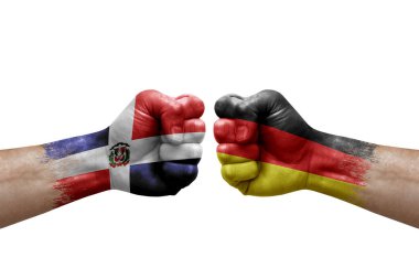 Two hands punch to each others on white background. Country flags painted fists, conflict crisis concept between dominican republic and germany
