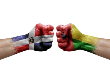 Two hands punch to each others on white background. Country flags painted fists, conflict crisis concept between dominican republic and guinea-bissau
