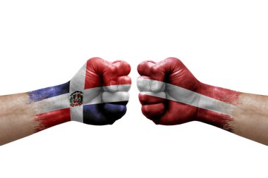 Two hands punch to each others on white background. Country flags painted fists, conflict crisis concept between dominican republic and latvia