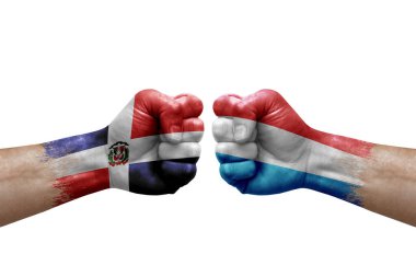 Two hands punch to each others on white background. Country flags painted fists, conflict crisis concept between dominican republic and luxembourg
