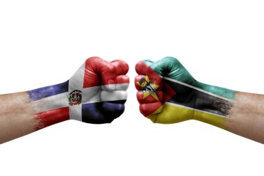 Two hands punch to each others on white background. Country flags painted fists, conflict crisis concept between dominican republic and mozambique