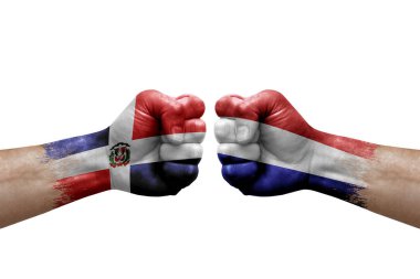 Two hands punch to each others on white background. Country flags painted fists, conflict crisis concept between dominican republic and netherlands