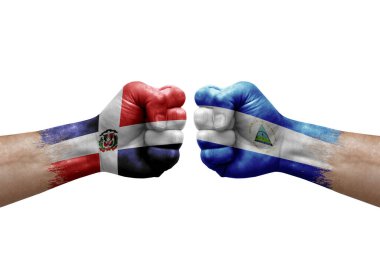 Two hands punch to each others on white background. Country flags painted fists, conflict crisis concept between dominican republic and nicaragua