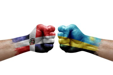Two hands punch to each others on white background. Country flags painted fists, conflict crisis concept between dominican republic and rwanda