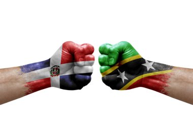 Two hands punch to each others on white background. Country flags painted fists, conflict crisis concept between dominican republic and saint kitts and nevis