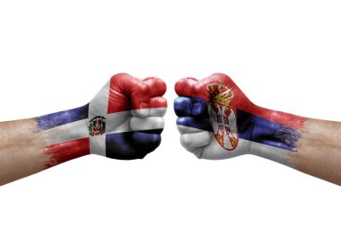 Two hands punch to each others on white background. Country flags painted fists, conflict crisis concept between dominican republic and serbia