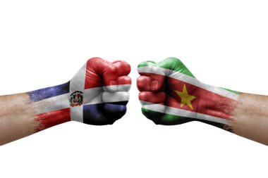 Two hands punch to each others on white background. Country flags painted fists, conflict crisis concept between dominican republic and suriname