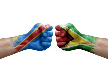 Two hands punch to each others on white background. Country flags painted fists, conflict crisis concept between dr congo and guyana