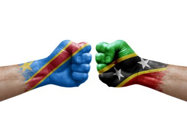 Two hands punch to each others on white background. Country flags painted fists, conflict crisis concept between dr congo and saint kitts and nevis