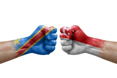 Two hands punch to each others on white background. Country flags painted fists, conflict crisis concept between dr congo and singapore