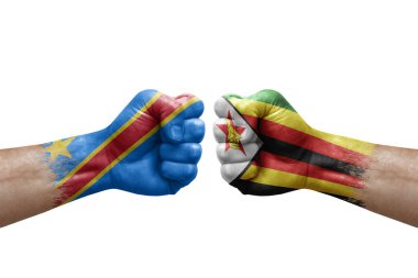 Two hands punch to each others on white background. Country flags painted fists, conflict crisis concept between dr congo and zimbabwe