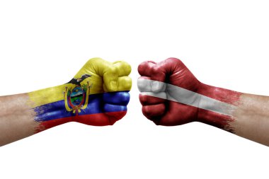 Two hands punch to each others on white background. Country flags painted fists, conflict crisis concept between ecuador and latvia