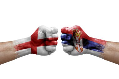 Two hands punch to each others on white background. Country flags painted fists, conflict crisis concept between england and serbia