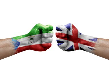 Two hands punch to each others on white background. Country flags painted fists, conflict crisis concept between equatorial guinea and britain