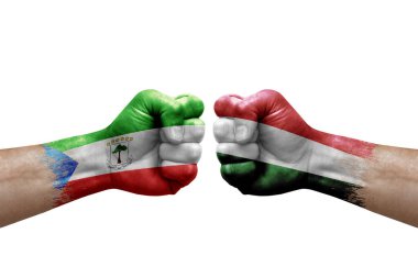 Two hands punch to each others on white background. Country flags painted fists, conflict crisis concept between equatorial guinea and hungary