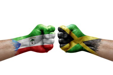 Two hands punch to each others on white background. Country flags painted fists, conflict crisis concept between equatorial guinea and jamaica