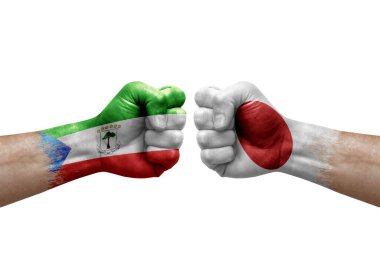 Two hands punch to each others on white background. Country flags painted fists, conflict crisis concept between equatorial guinea and japan