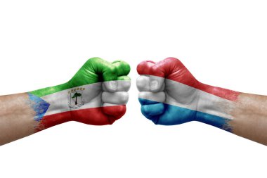 Two hands punch to each others on white background. Country flags painted fists, conflict crisis concept between equatorial guinea and luxembourg