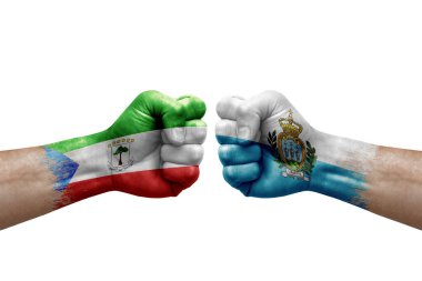 Two hands punch to each others on white background. Country flags painted fists, conflict crisis concept between equatorial guinea and san marino