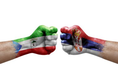 Two hands punch to each others on white background. Country flags painted fists, conflict crisis concept between equatorial guinea and serbia